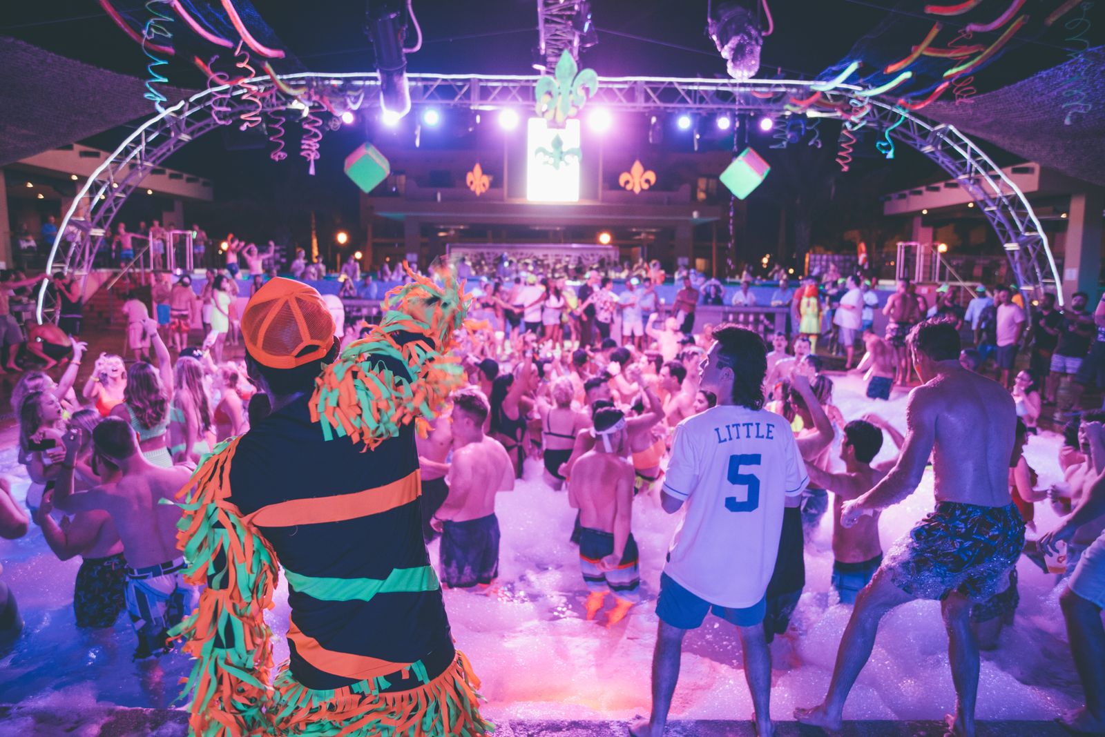 Nattlig skumparty med neonlys, scenerigg og fullt dansegulv
