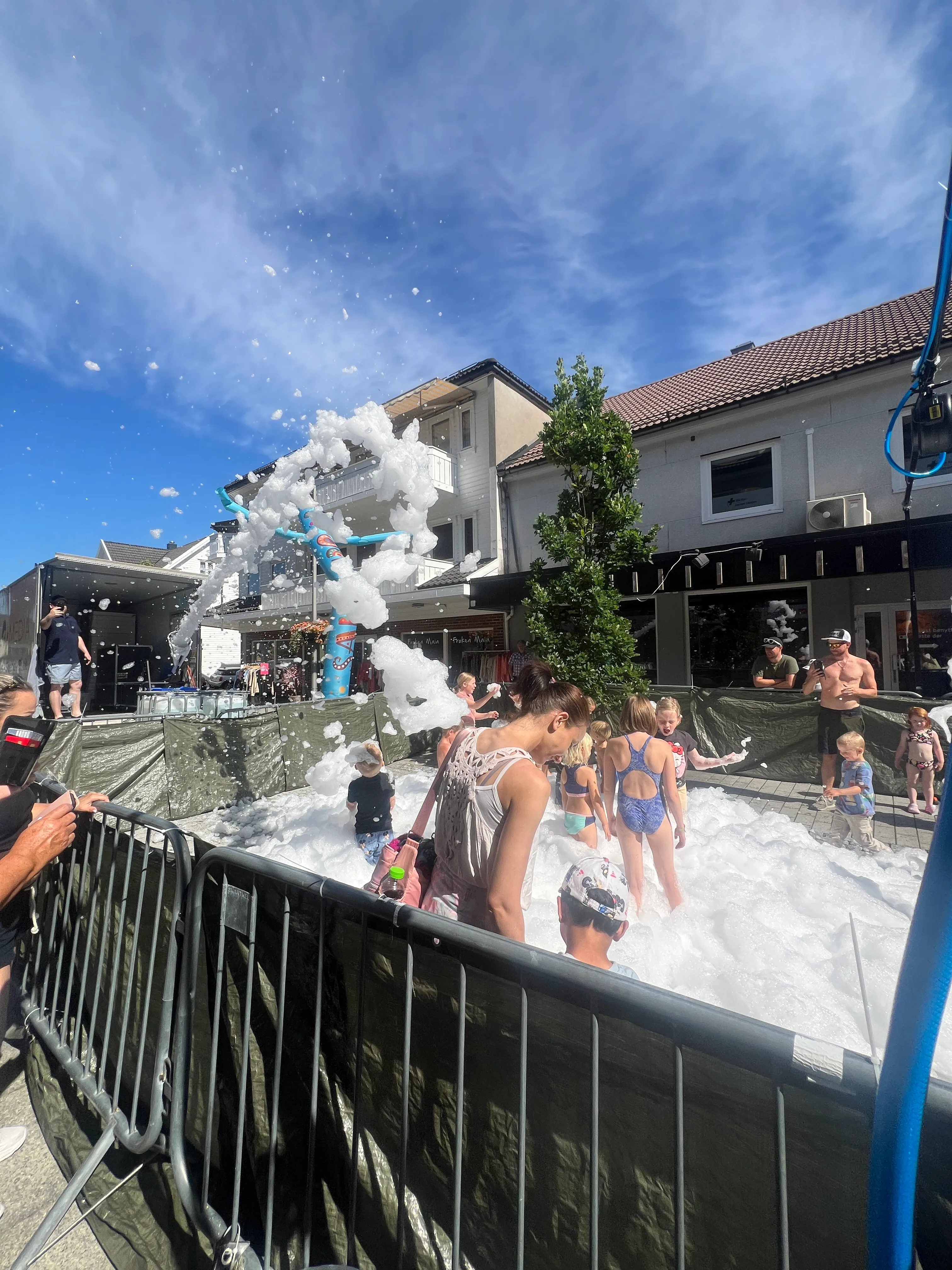 Barn og foreldre leker i skumbinge på et sommerarrangement